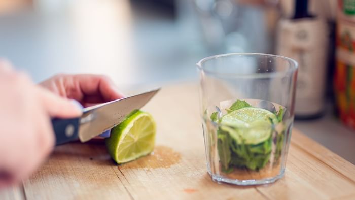 A bartender slicing a lime for a cocktail at Originals Hotels