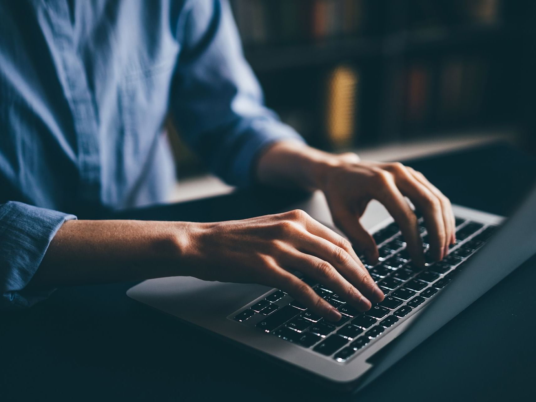 Close-up of a person typing on a laptop at Henn Na Hotel New York