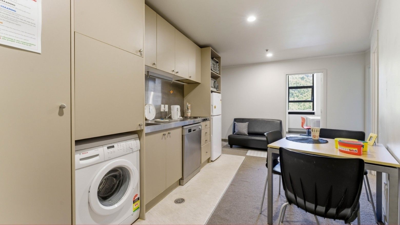 Compact kitchen with dining area and couch in UniLodge Stafford House.