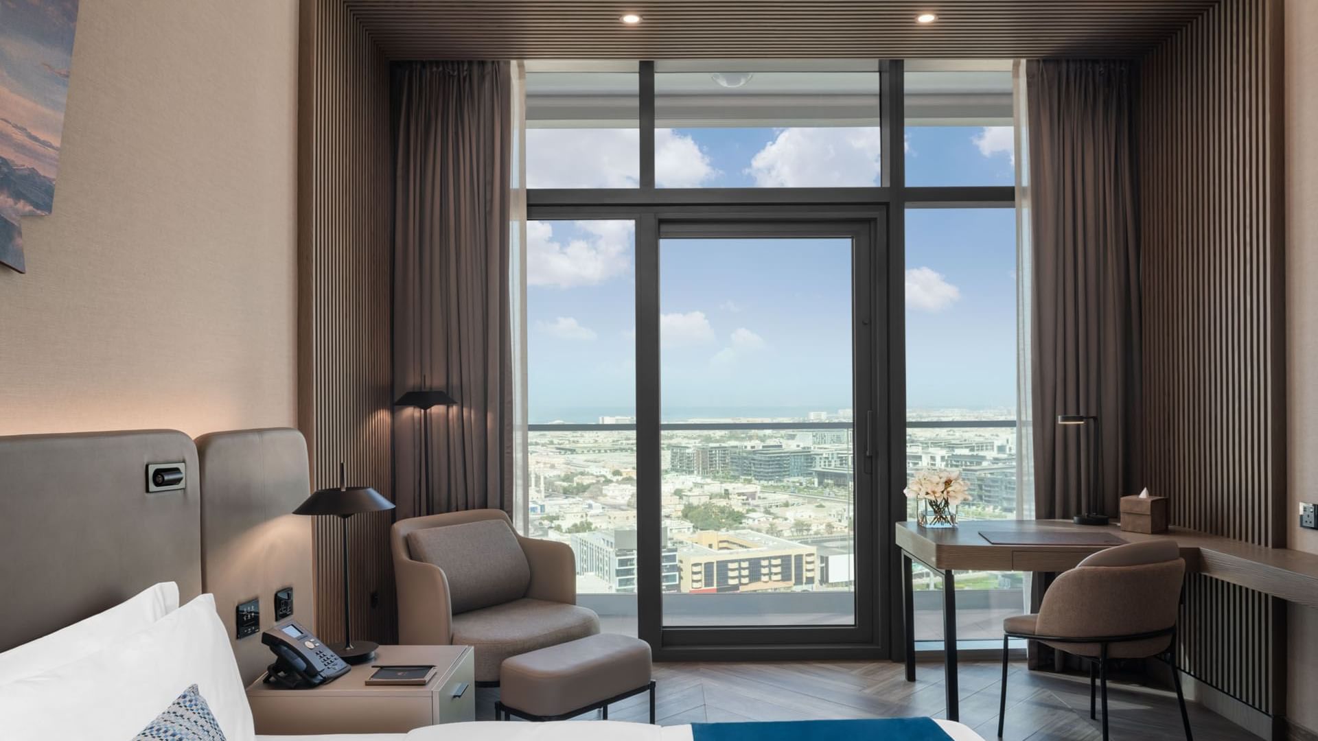 Workspace and cozy seating area by the bed in Scene Room with a city view at Paramount Hotel Midtown