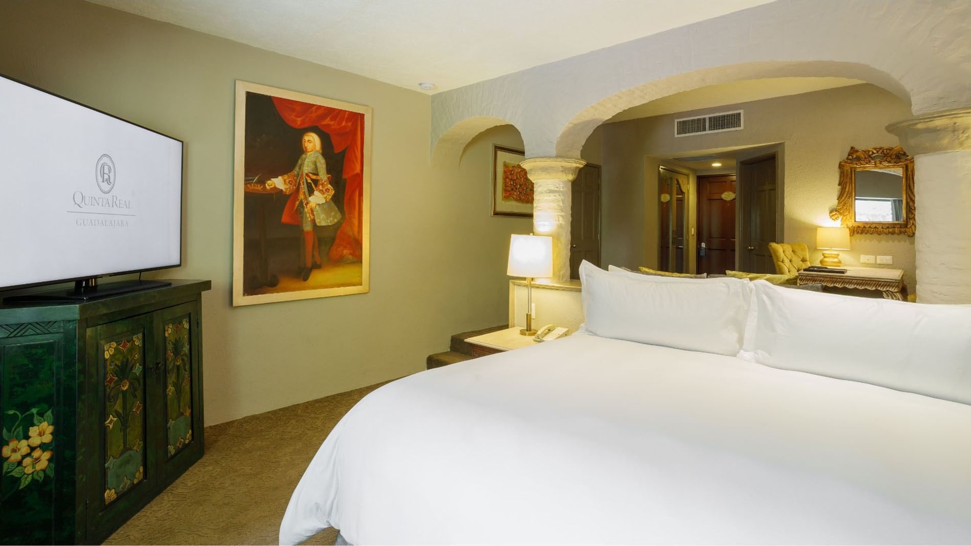 King Master Suite featuring a historical portrait and a large bed, at the Quinta Real Guadalajara