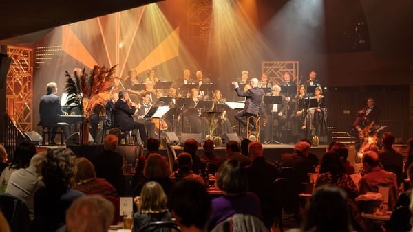 Musicians performing on stage under spotlights in front of an audience near Warwick Grand Place Brussels
