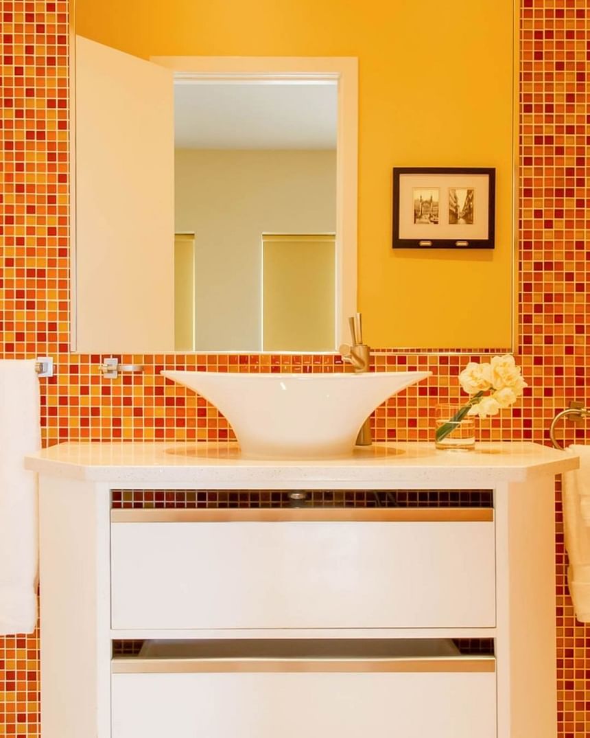 orange tile bathroom with raised white sink mirror 