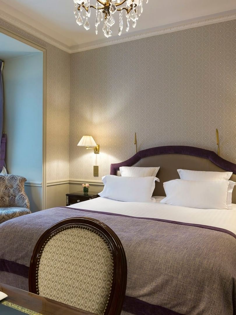 Bed between the side tables with a work desk in Executive Room at Hotel Westminster Paris