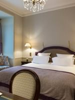 Bed between the side tables with a work desk in Executive Room at Hotel Westminster Paris