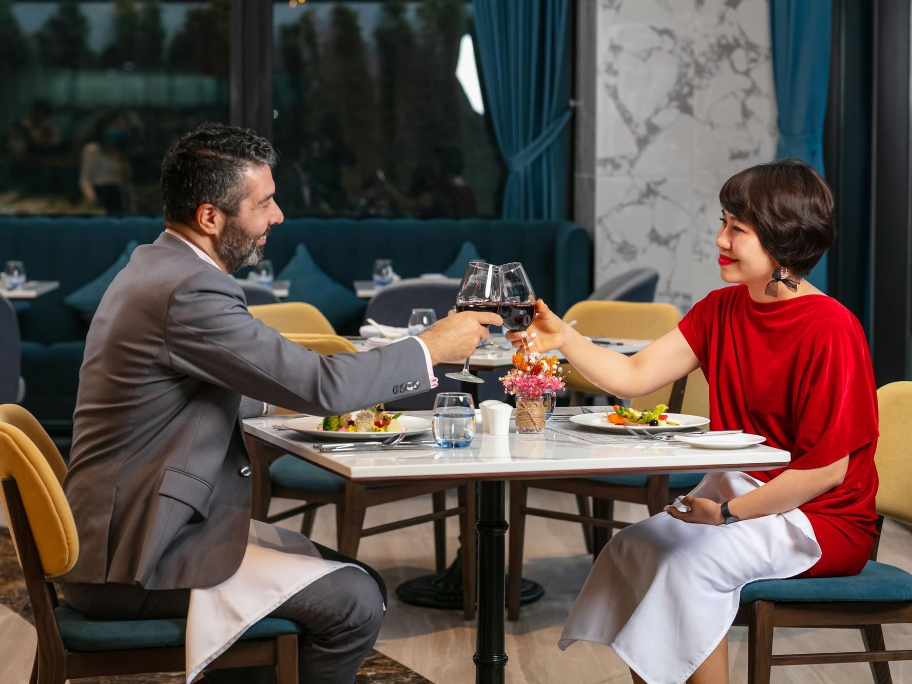 A couple toasting wine glasses at restaurant in Eastin Hotels