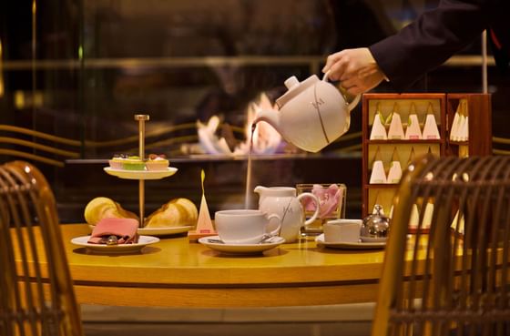 Bartender pouring tea into a cup at Cristóvão Colombo Bar of Hotel Cascais Miragem Health & Spa