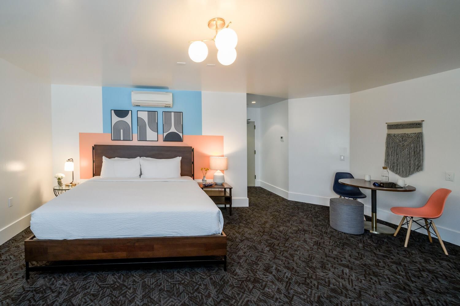 A wide view of a hotel room with a large bed, desk, and chair.
