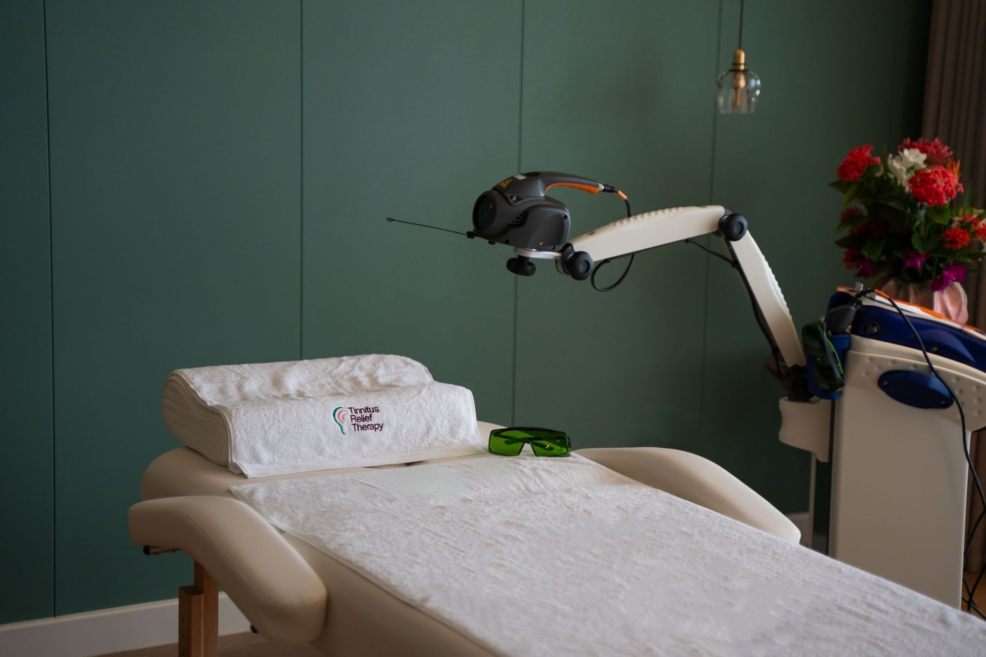 Behandelbed met handdoek en laserapparaat in Tinnitus Relief Therapy bij Golden Rock Resort