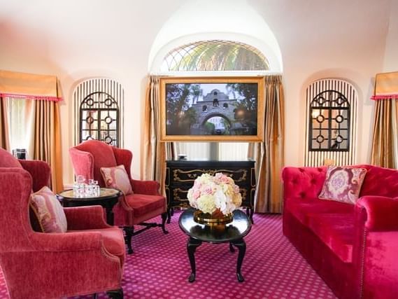 living room with pink sofa, chairs and carpet