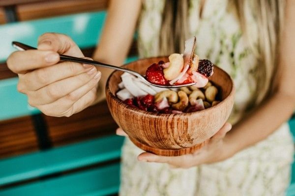 A woman holding a spoonful of an acai bowl at Rosen Inn International in Orlando.