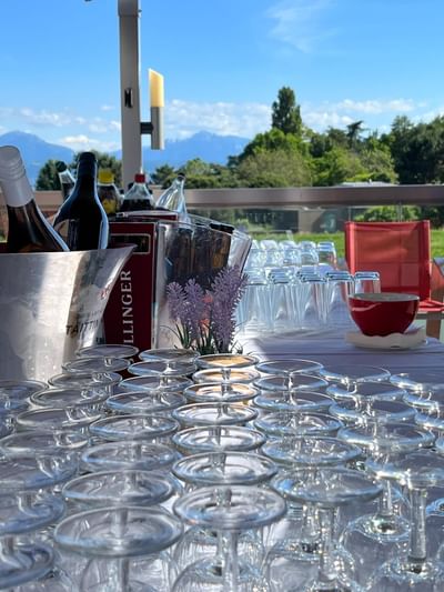 Wine bottles in ice bucket and rows of glasses on terrace at Starling Hotel Lausanne