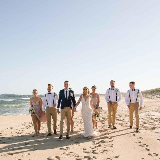 Wedding couple taking photos with crew near Pullman Magenta Shores