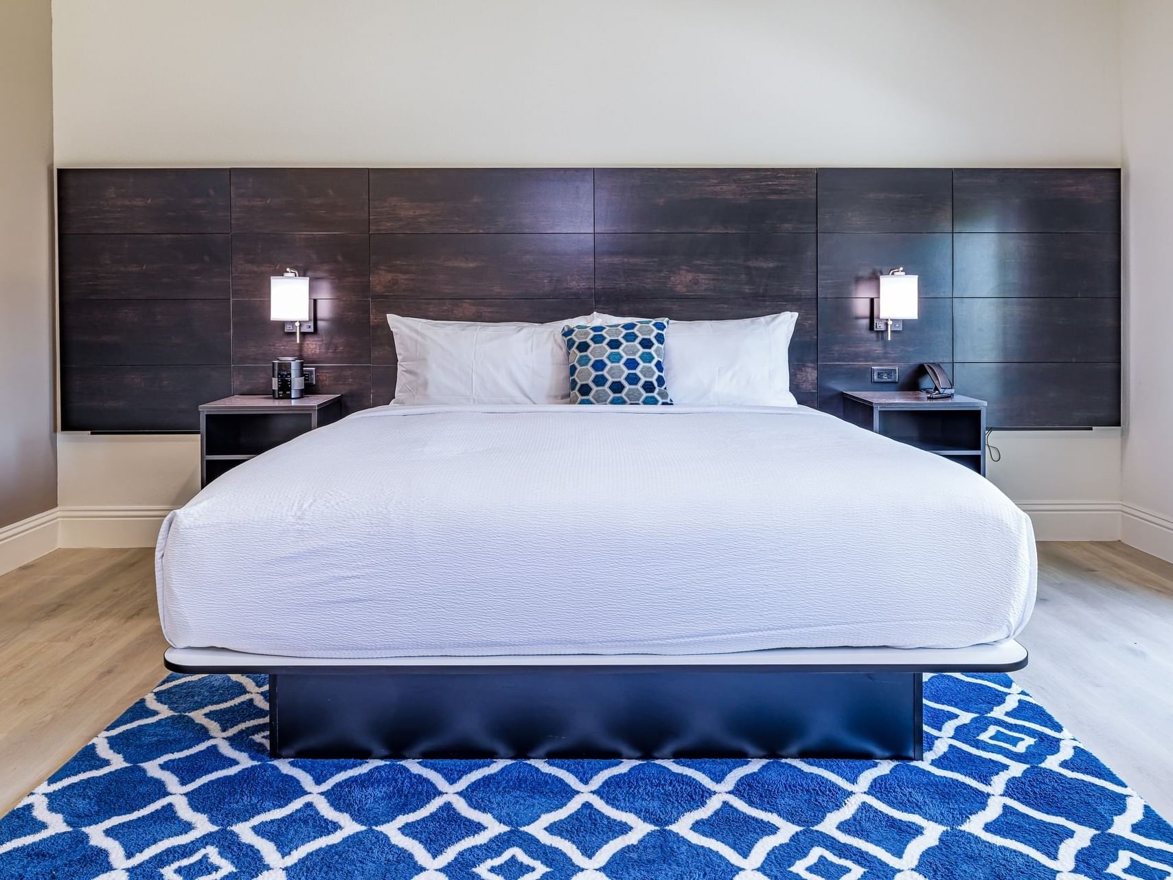 King bed featuring bedside lamps & carpeted floor in Premier Garden King Balcony Room at Grant Street Inn