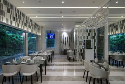 Arranged dining area by the reception in The Glass House at Eastin Residences Vadodara