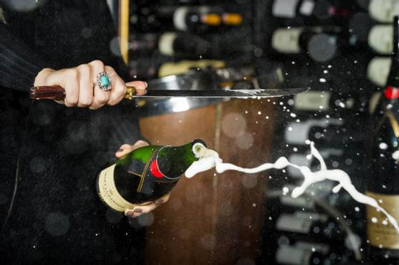 Bar tender opening a champagne bottle at Blackcomb Springs Suites