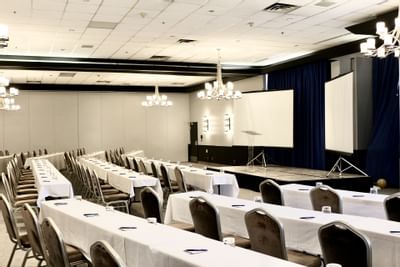 rangées de tables face à des écrans de projection