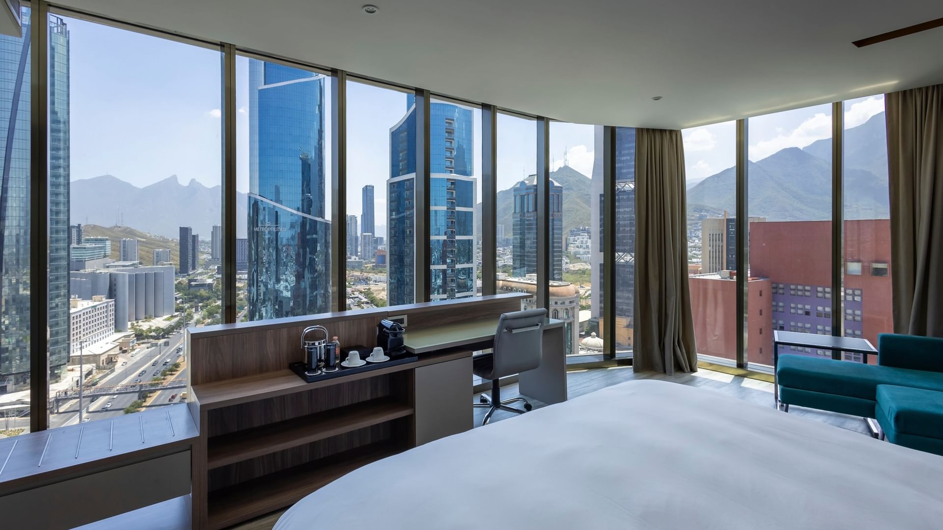 Junior Suite con cama king, ventanales amplios y vistas panorámicas a la ciudad en Camino Real Fashion Drive Monterrey