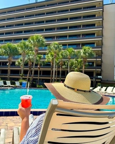 A guest sitting poolside at Rosen Inn International while visiting Orlando in December.