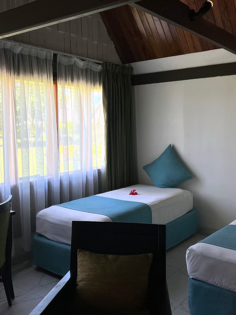 Garden View Bure interior with two beds, desk, and garden view at Tambua Sands Beach Resort - Fiji.