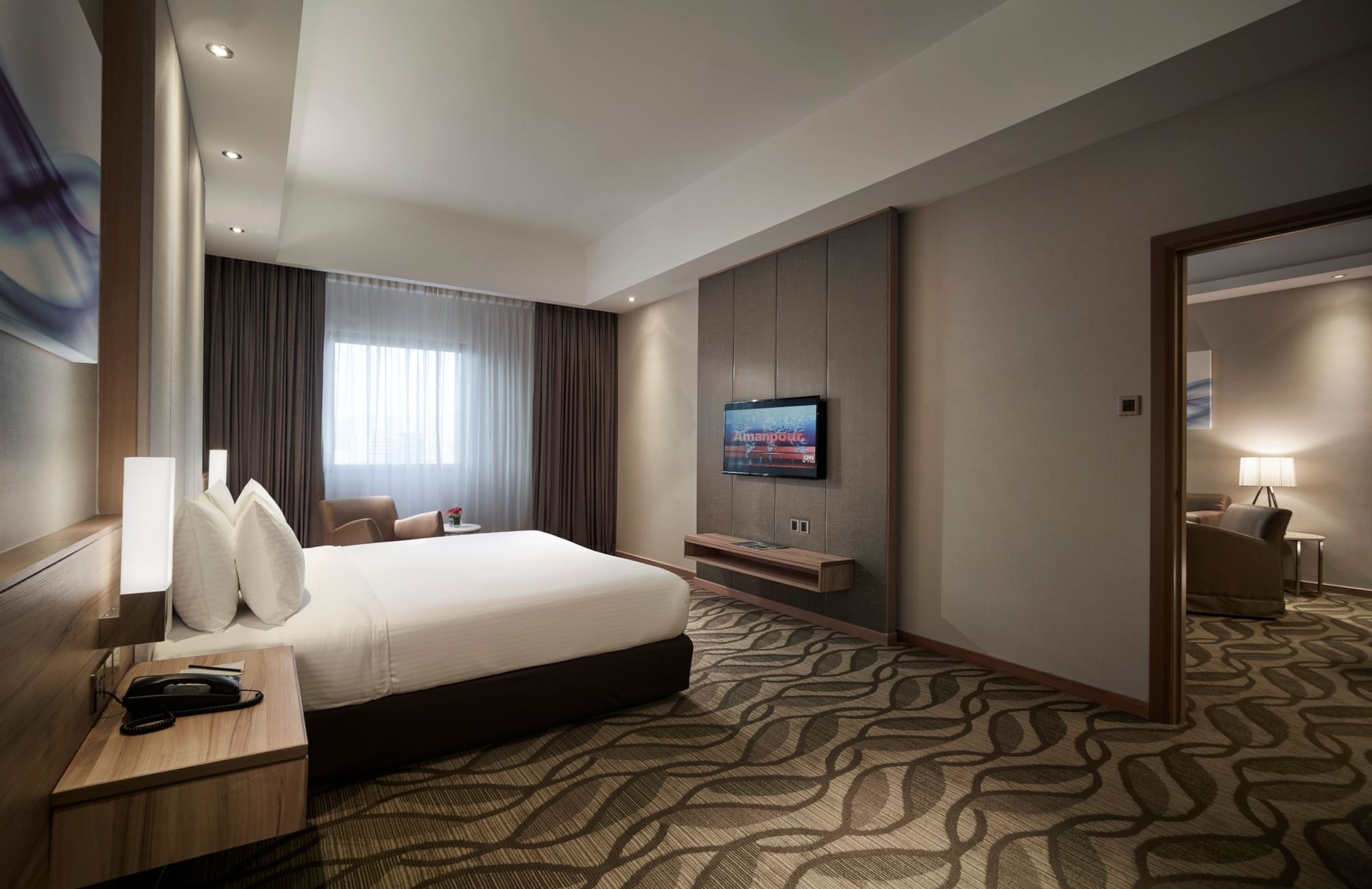 King-size bed with a TV in Club Suite at Sunway Putra Hotel