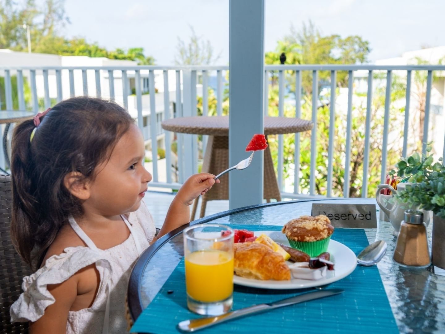 Girl eating breakfast on a balcony at Savannah Beach Hotel.
