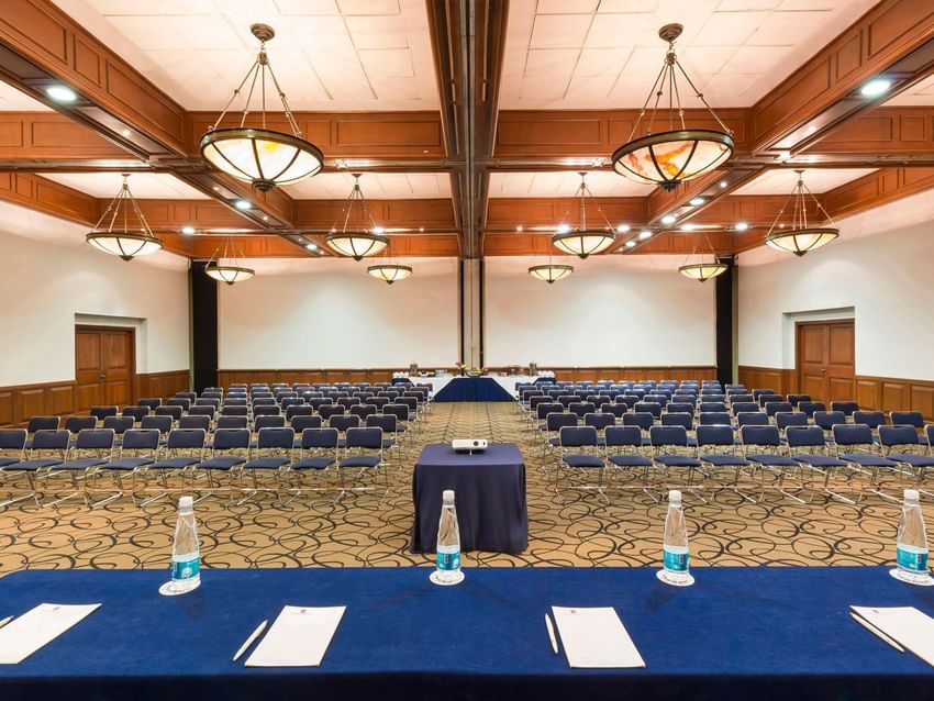 Camino Real meeting room featuring rows of blue chairs and wooden ceilings at Camino Real Puebla Angelopolis