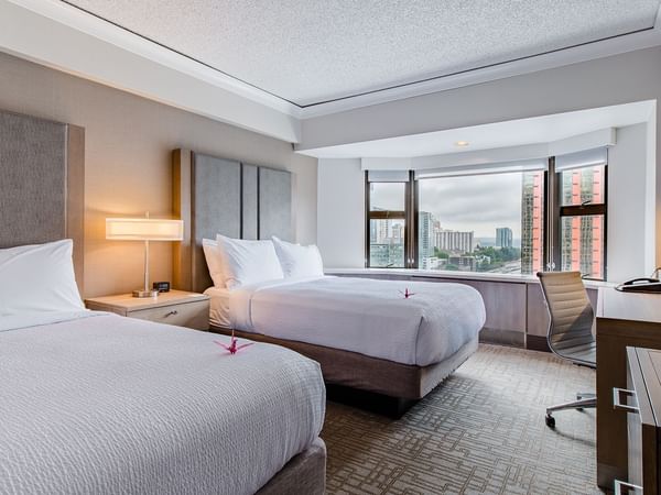 Hotel guestroom with two beds, TV and desk