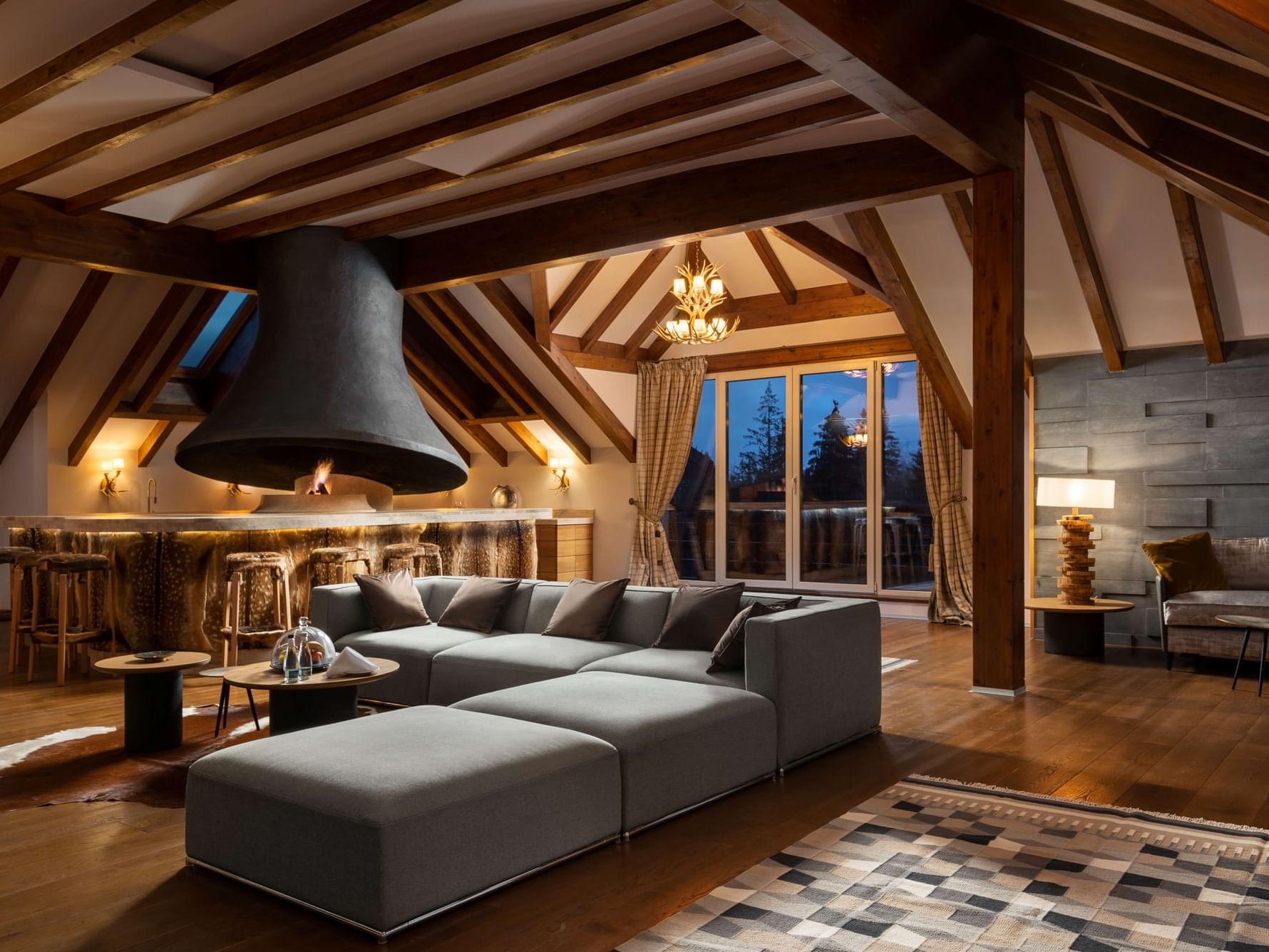 Royal Suite with sofa, wooden beams, central fireplace and bar area at Ana Hotels Sport Poiana Brașov