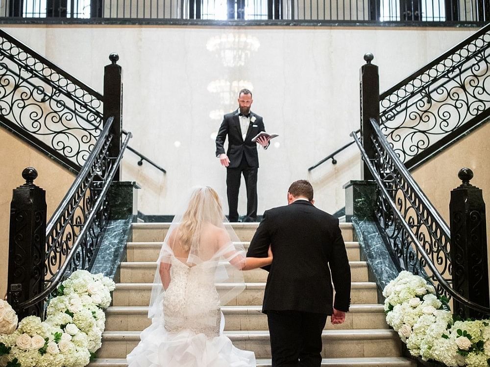 Bride & groom walking up stairs at The Mayo Hotel