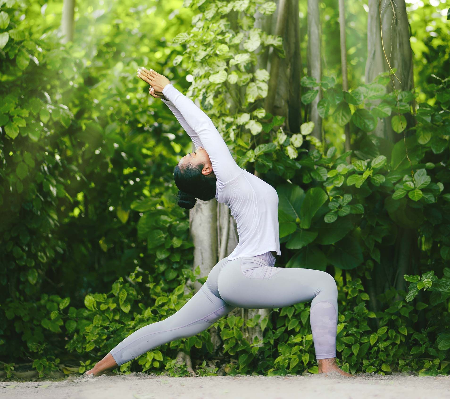 A woman engaged in yoga in the forest, The Signature Collection