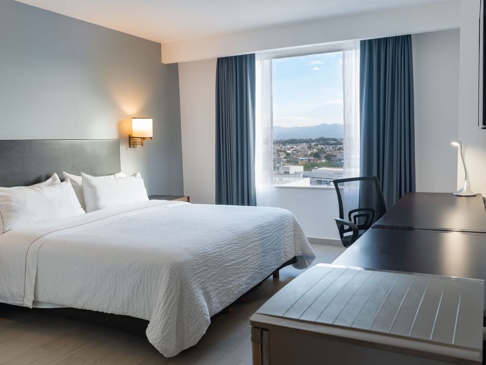 Prime Suite with double bed, window and work desk with chair at Fiesta Inn