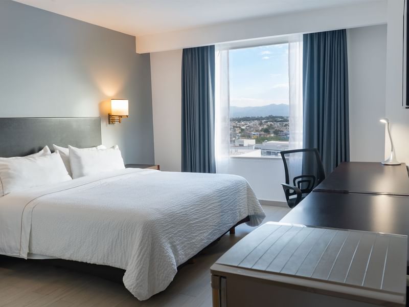 Prime Suite with double bed, window and work desk with chair at Fiesta Inn