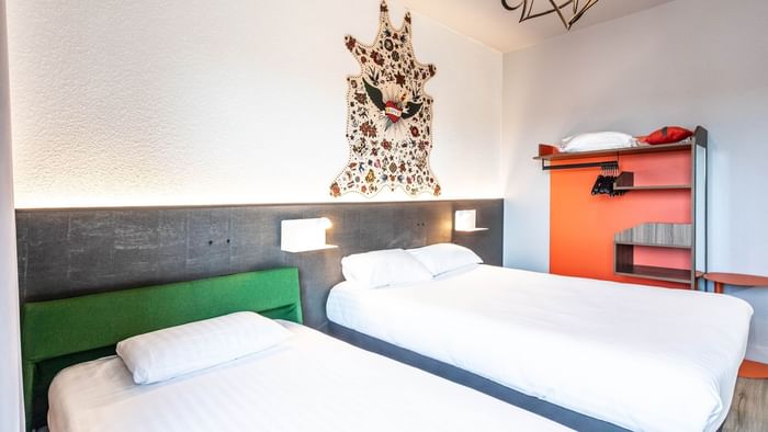 Twin beds with wooden wall cupboard at Hotel Le Berry