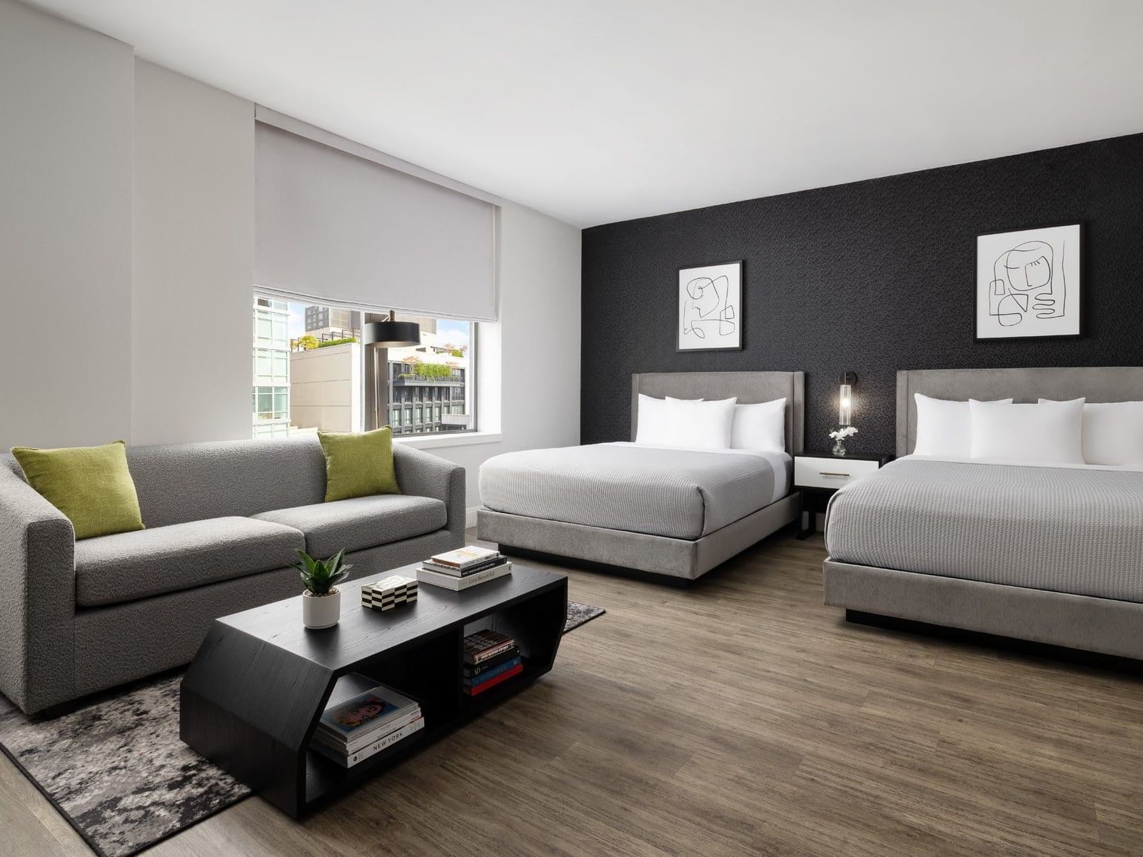 Spacious junior suite with two queen beds, gray sofa, and modern decor at ArtHouse Hotel New York City.