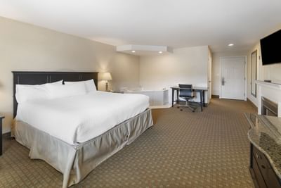 Spacious Luxury Suites at Ogunquit Hotel and Suites with a cozy bed, desk, jetted tub, and warm modern decor