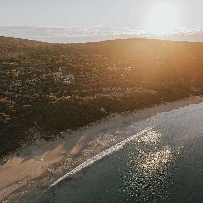 Sunset over coastal resort with beach and ocean view, highlighting Winter Wellbeing Meeting Offer.