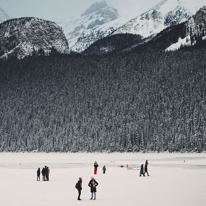 People on a frozen lake near a mountain, Falkensteiner Hotels