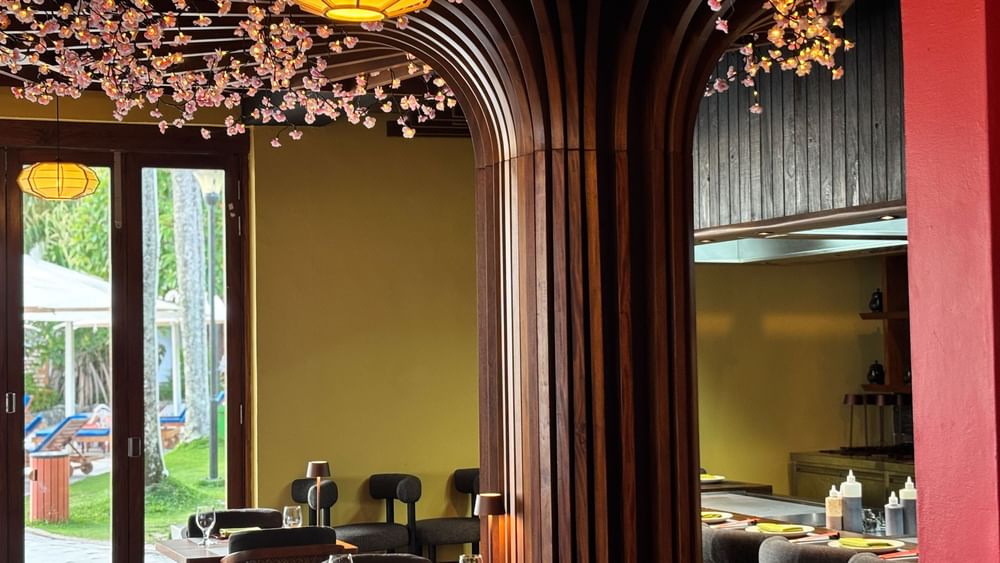 Sazanami restaurant interior with wooden tables, chairs, and floral lighting at Warwick Fiji Resort and Spa, Korolevu.