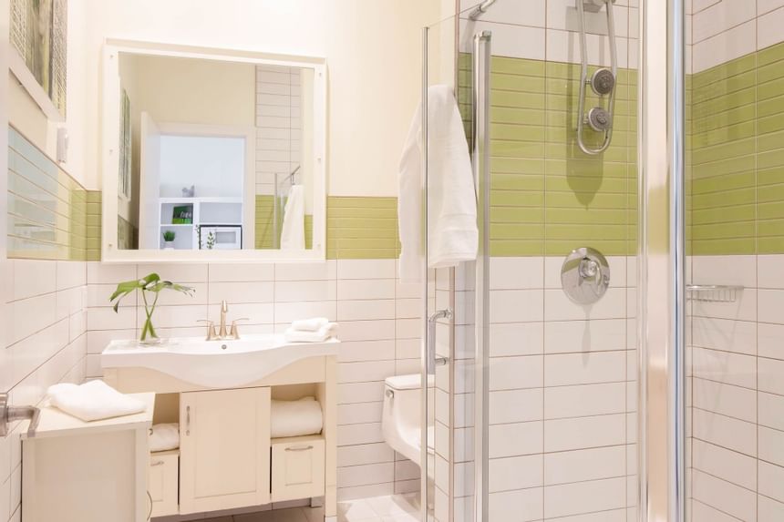 bathroom with green and white tiled glass walk in shower 