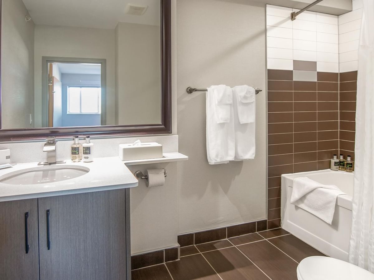 Bathroom with sink, towels, bathtub, and toilet.