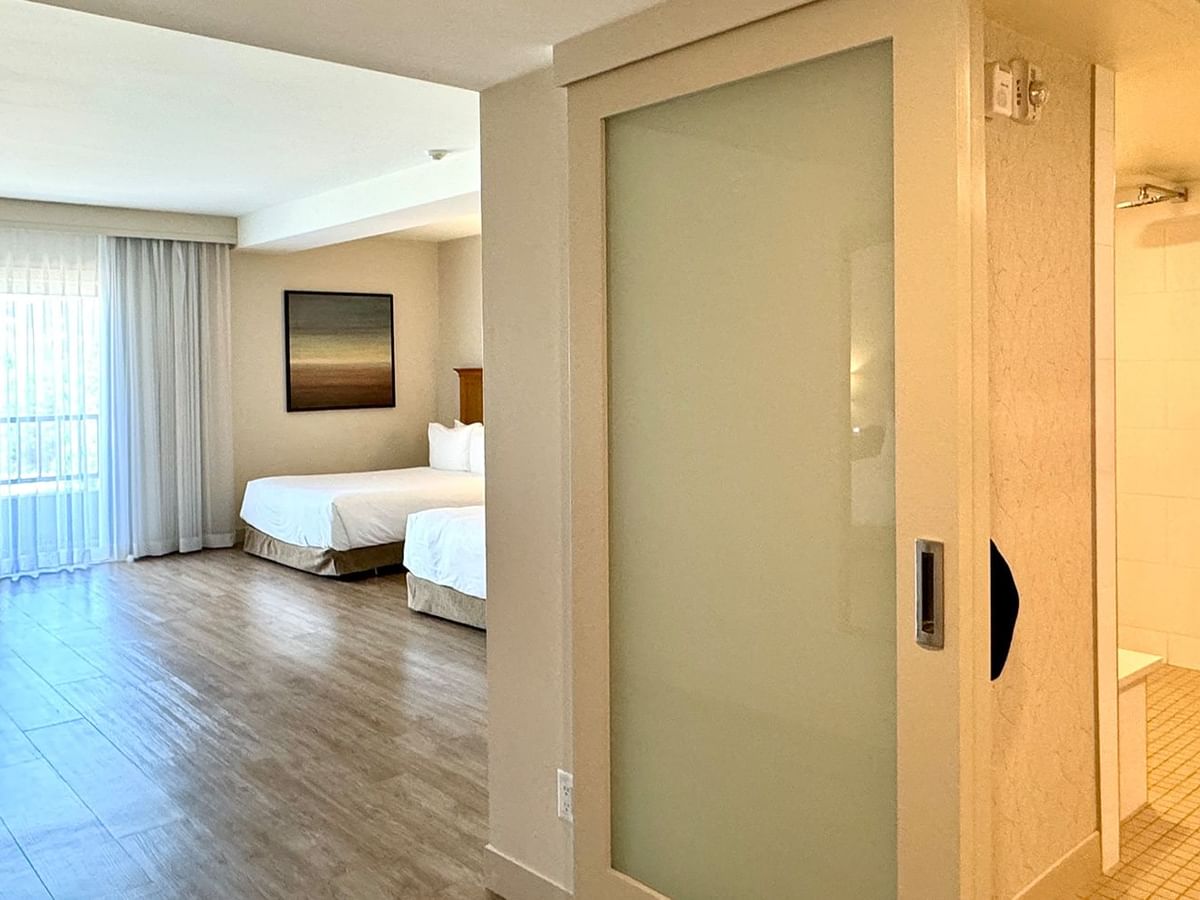 Hotel guestroom with two queen beds and an accessible washroom