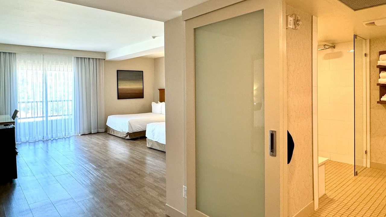 Hotel guestroom with two queen beds and an accessible washroom