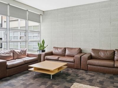 Brown couches and coffee table in a lounge area at Student Living Auckland – Anzac.