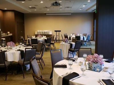 large conference room with circular tables with flower centerpie