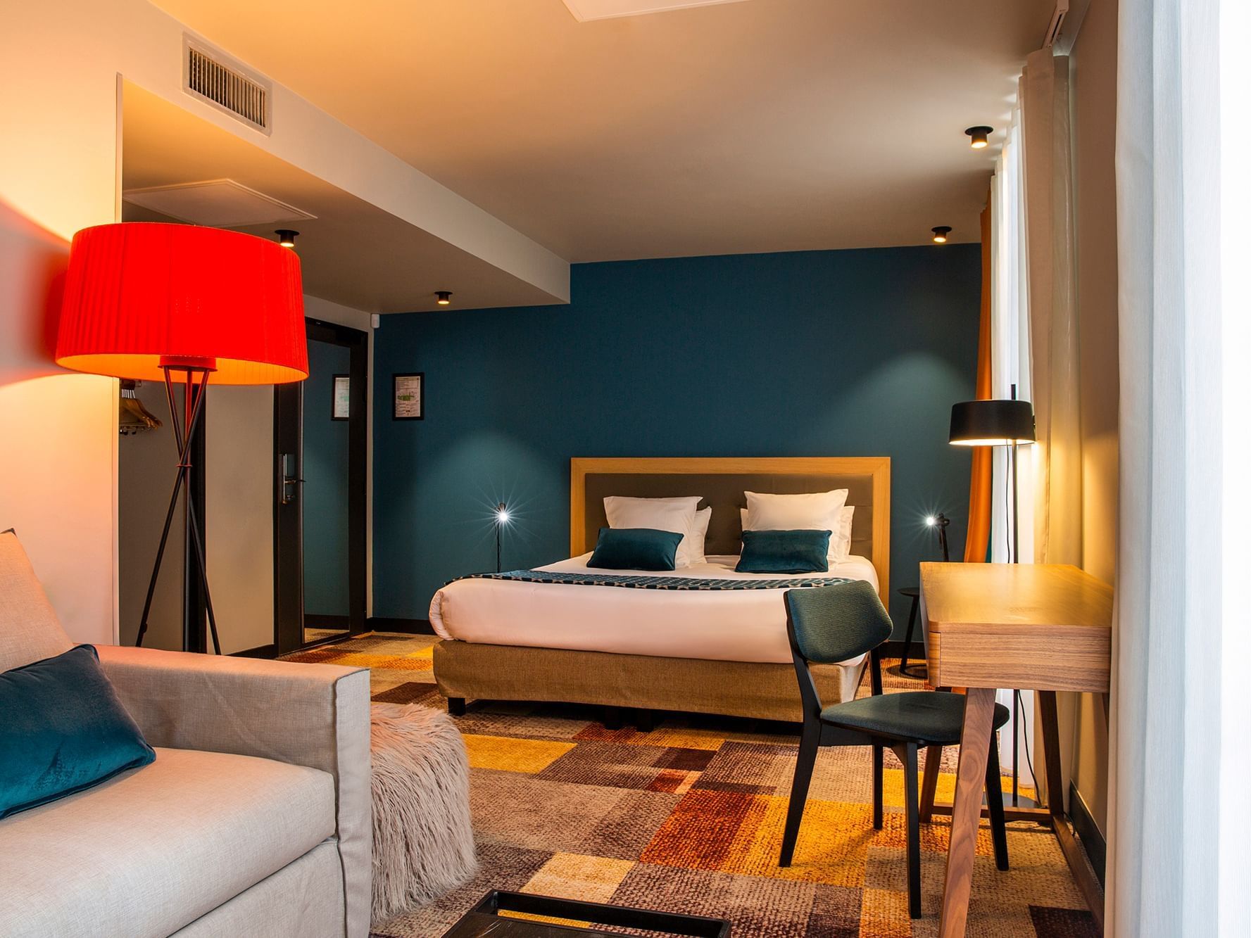 Room with a king bed, desk & sofa at The Originals Hotels