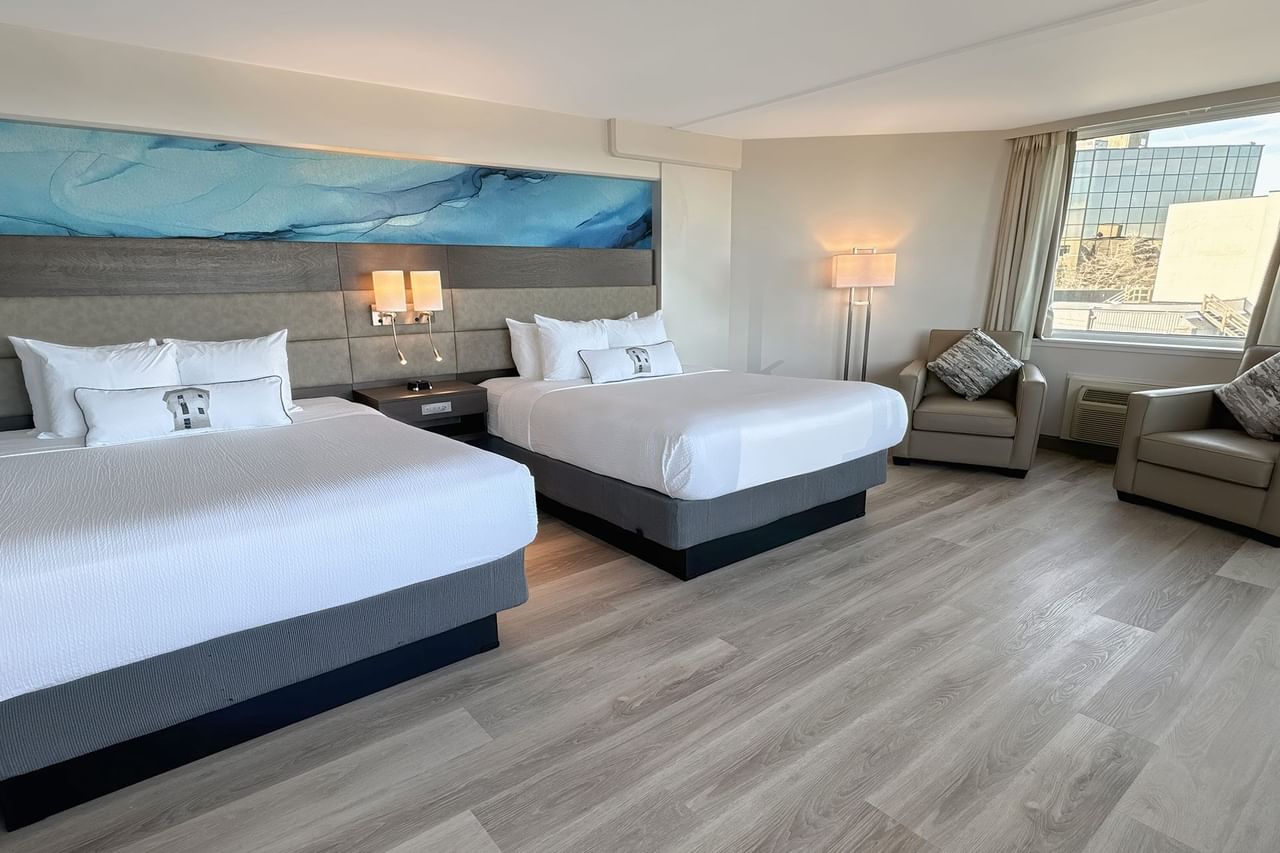 Hotel guestroom with two queen beds and a blue wall mural