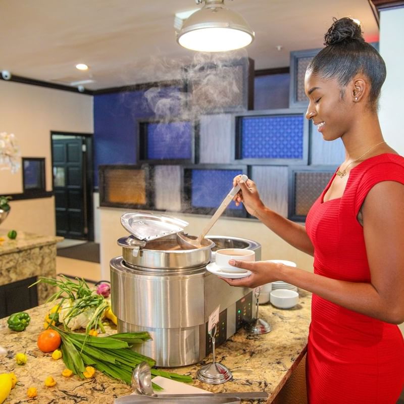 Woman pouring soup into the bowl in Sunday Brunch at Jamaica Pegasus Hotel