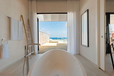 Minimalist Water Pool Villas bathroom at Ananea Madivaru Maldives with a bathtub and ocean views from a wooden deck