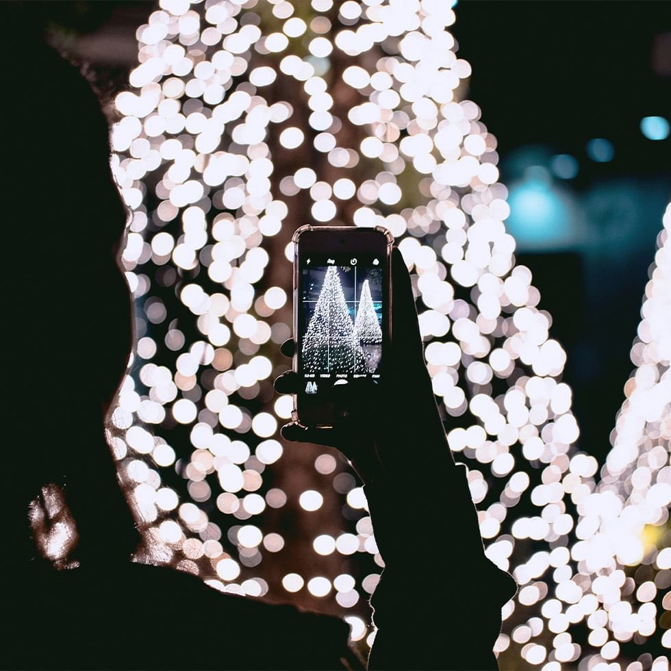 Lady taking photos of Christmas trees at Falkensteiner Hotel Schladming